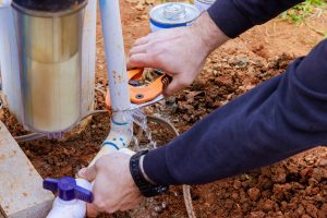 Using special pair of scissors, technician plumber cuts a PVC pipe made of plastic